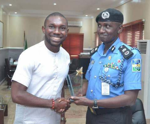 Samuel Uchenna, executive director of Levites Initiative for Freedom and Enlightenment, presents an award to Muhammad Mustafa, the police commissioner for Delta State, Nigeria. The award honors him as as an effective and friendly police officer. (Mike Daemon photo)