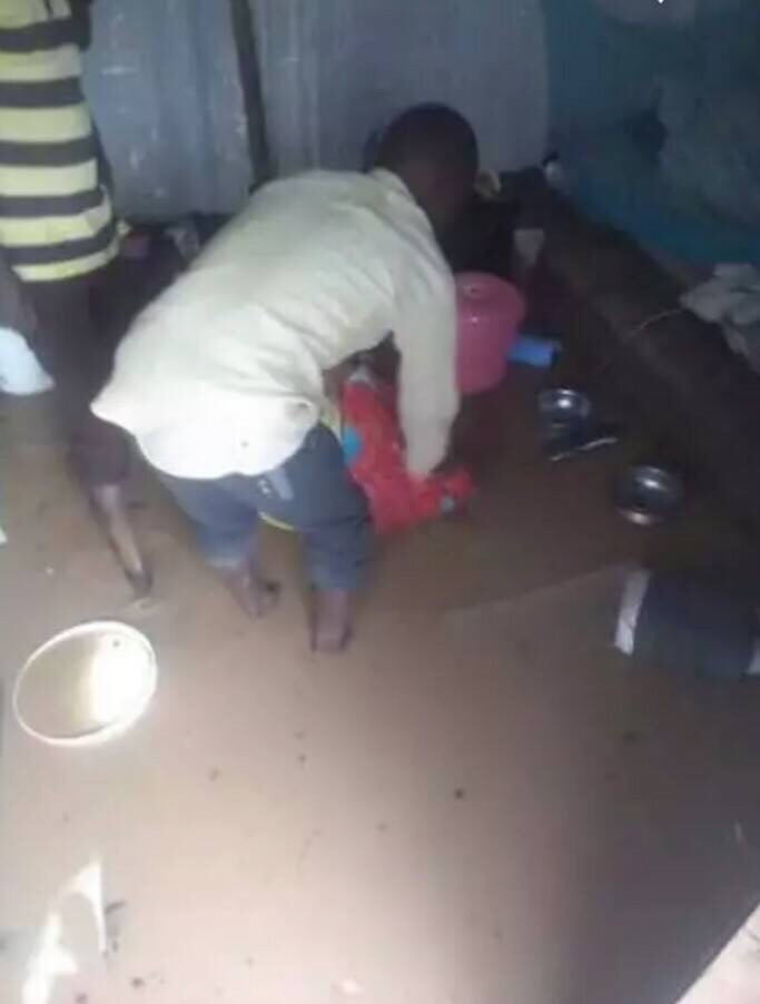 LGBTI refugee in Kakuma Camp wades into his flooded shelter to retrieve household items. (Photo courtesy of Moses Mbazira)