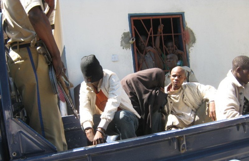 After their conviction in Zambia on Aug. 3 for homosexual activity, two men are loaded into a pickup truck to be transported back to jail. (Photo courtesy of Lusaka Times)