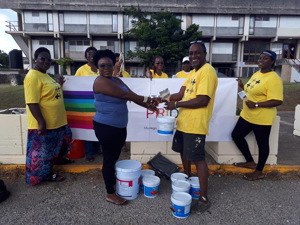 Paint-splattered volunteers from Montego Bay Pride pose with an administrator from Cornwall Regional Hospital. (Photo courtesy of Maurice Tomlinson)
