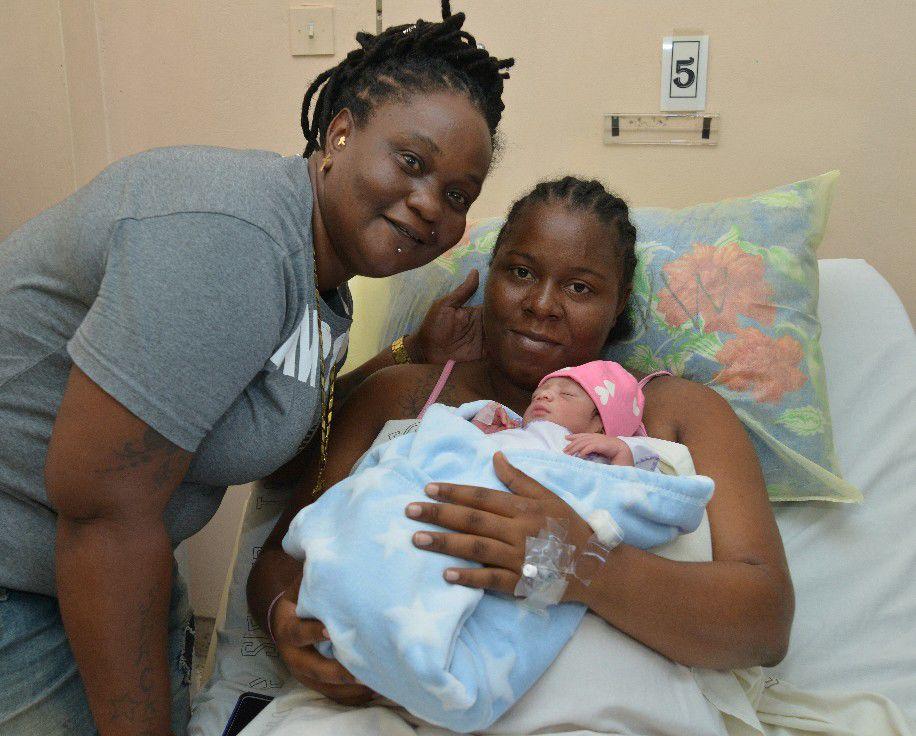 Shaciba St Louis, right, and her girlfriend, Lisa Melville, hold their daughter, Miracle, who was born at 6:03 a.m. on Jan. 1 at the Mt. Hope Women’s Hospital in Trinidad. (Ishmael Sanandy photo courtesy of Trinidad Express)