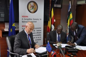 Ambassador Pacifici (left) signs an agreement with Uganda's finance minister, Matia Kasaija, to fund public road rehabilitation. (Photo courtesy of the European Union)