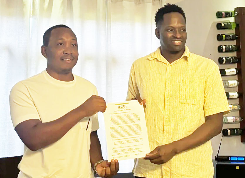 Businessman Enzo Christopher (left) and SASOD’s managing director, Joel Simpson (right), pose with the SASOD's list of demands on July 16. (Photo courtesy of Newsroom.gy)
