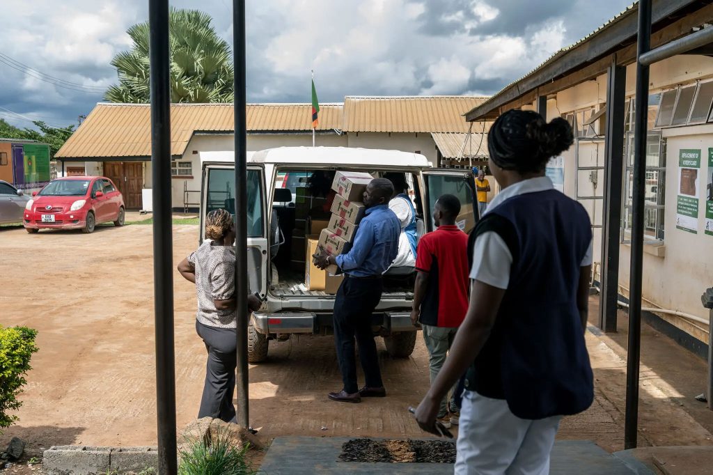 Health workers unload medicines at the Chipulukusu Health Center in northern Zambia earlier this month. (Arlette Bashizi photo courtesy of The New York Times)