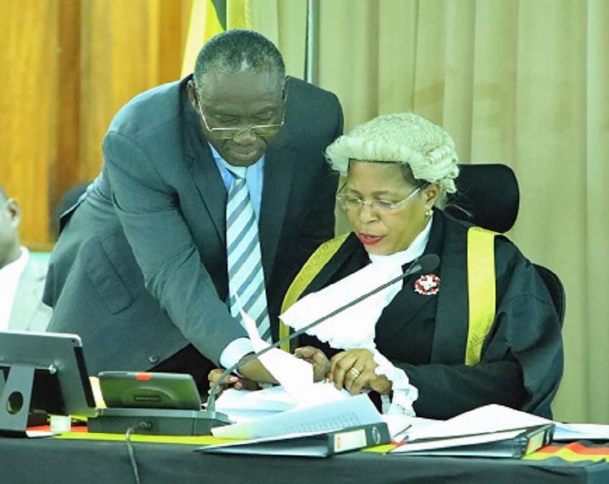 Patrick Isiagi, the chairperson of the parliamentary budget committee, confers with then Speaker Anita Among during 2024 budget deliberations. (Photo courtesy of the Parliament of Uganda)