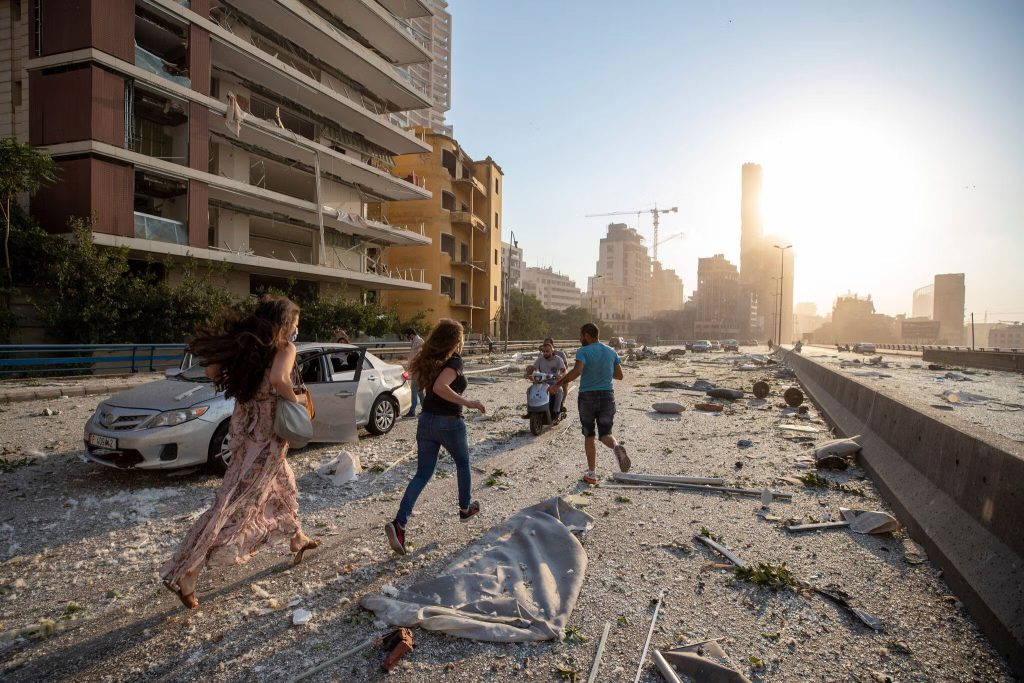 Several people run through the streets of Beirut, Lebanon after an explosion in August. (Hassan Ammar photo courtesy of AP / NY Times)